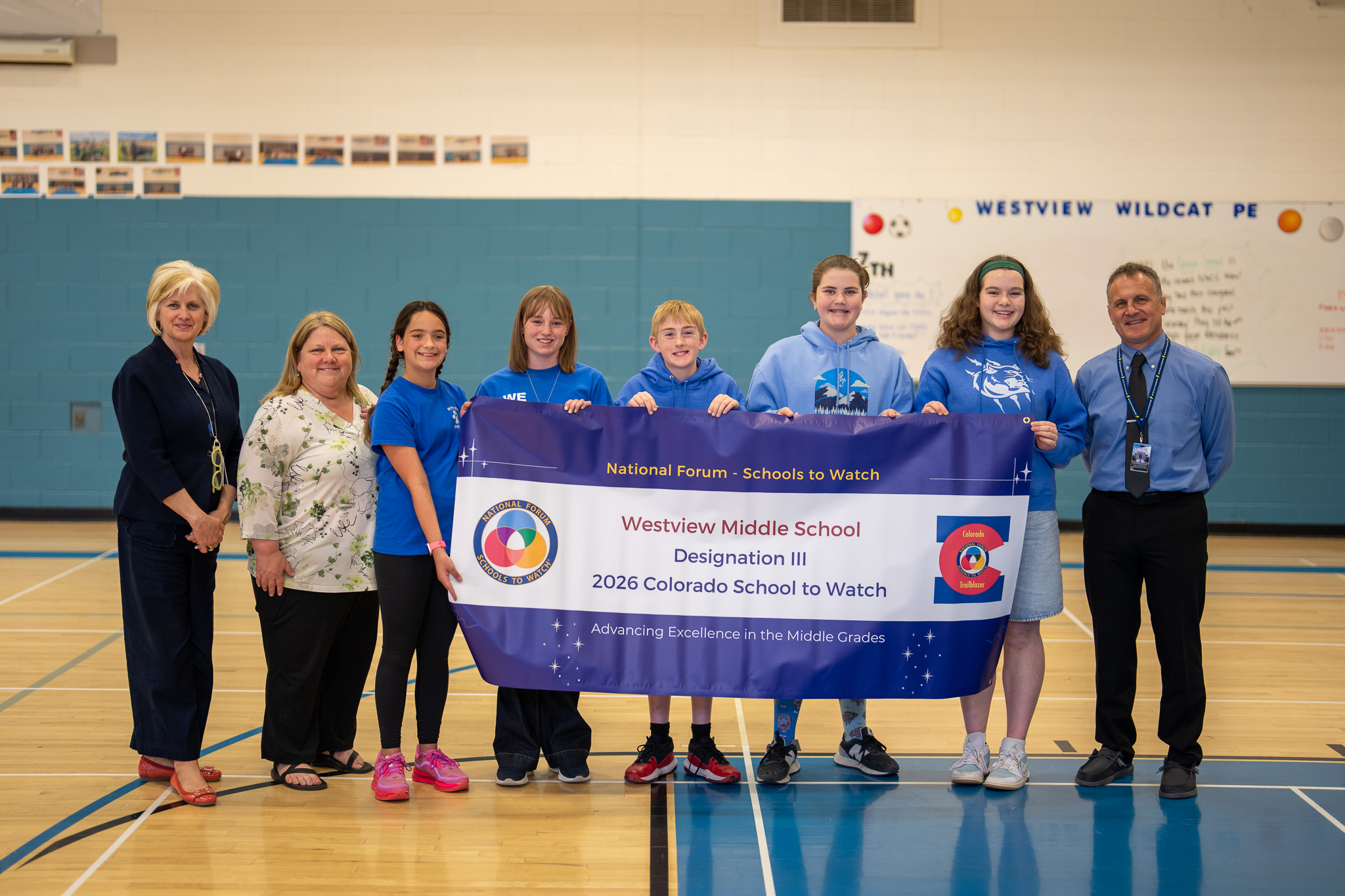 A group of students and adults proudly hold a banner recognizing Westview Middle School as a 2026 Colorado School to Watch.